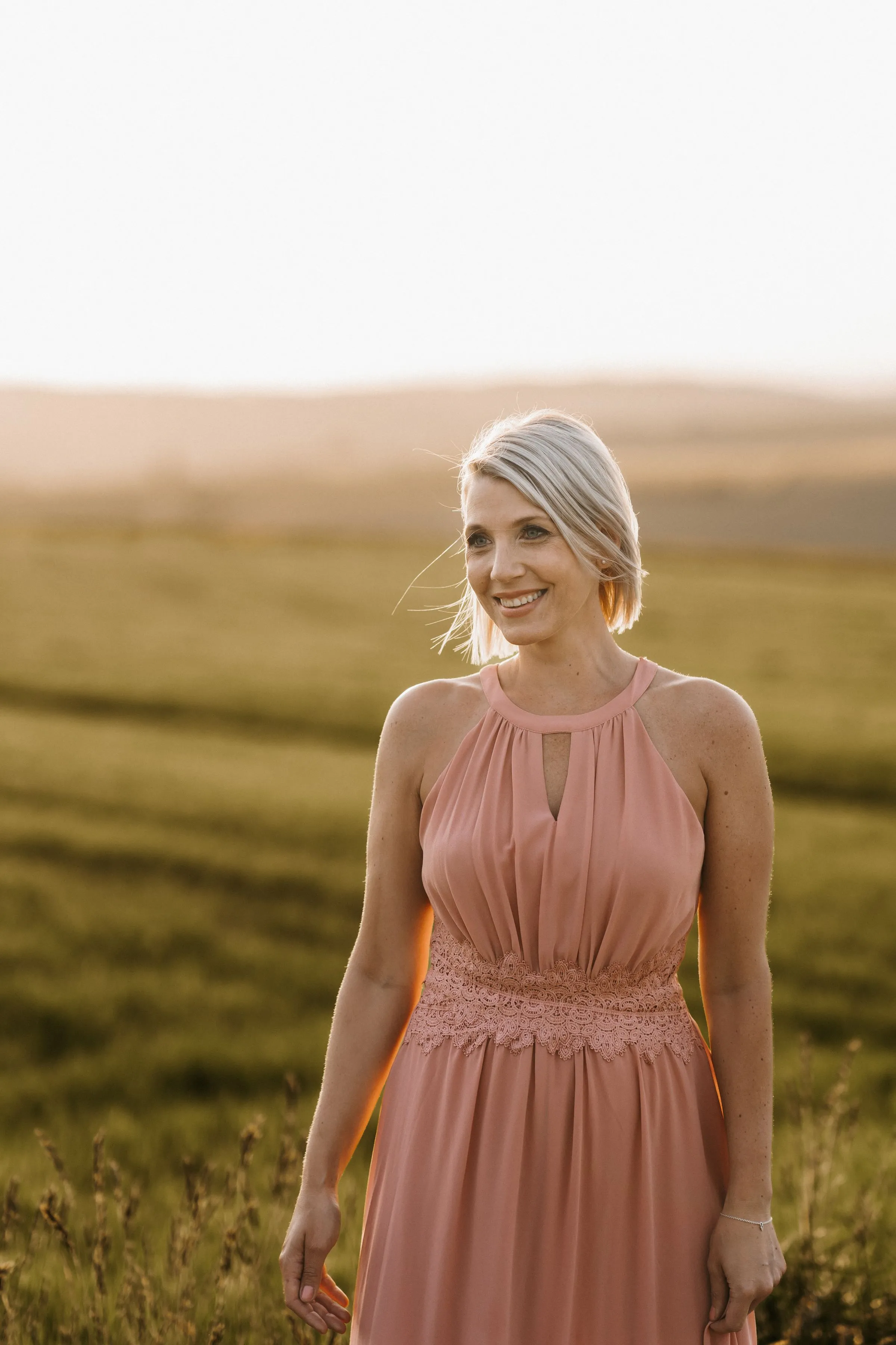 Portrait von Lisa Dietrich im rosafarbenen Kleid vor einem Feld