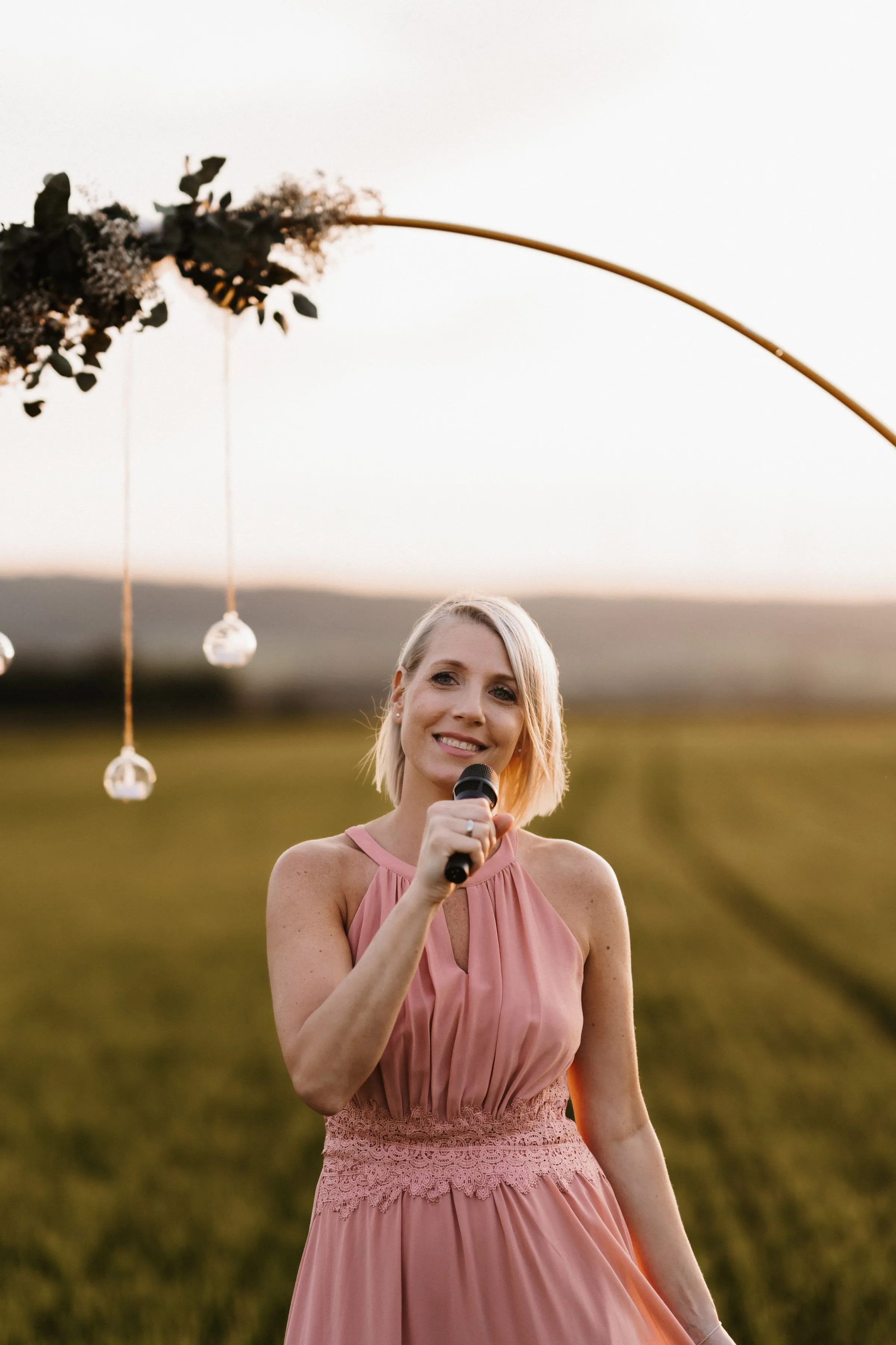 Lisa Dietrich singt mit Mikrofon im Abendlicht